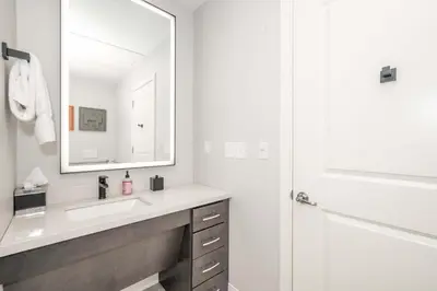 a white bathroom with a sink and a mirror at The 333 Suites 204 - Stay for 2 in Cincinnati