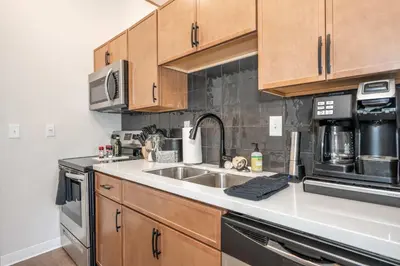 a kitchen with wooden cabinets and a sink at The 333 Suites 301 - Suite for 6 in Cincinnati