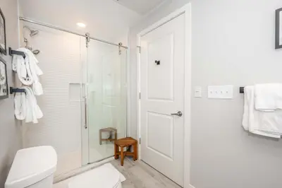 a white bathroom with a shower and a toilet at The 333 Suites 301 - Suite for 6 in Cincinnati