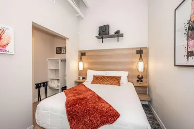 a bedroom with a white bed with a red blanket at The 333 Suites 301 - Suite for 6 in Cincinnati