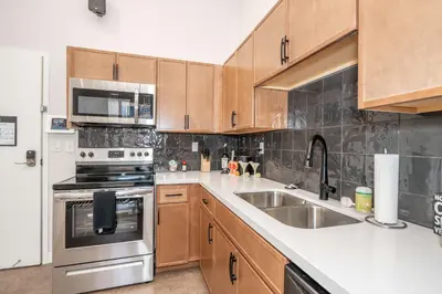a kitchen with stainless steel appliances and wooden cabinets at The 333 Suites 302 - Stay for 6 in Cincinnati