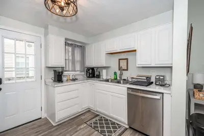 a kitchen with white cabinets and a sink at The Washington Cottage - 6ppl in Harrison