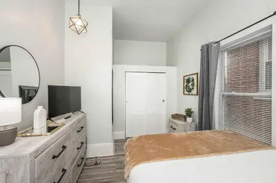 a white bedroom with a bed and a mirror at The Washington Cottage - 6ppl in Harrison
