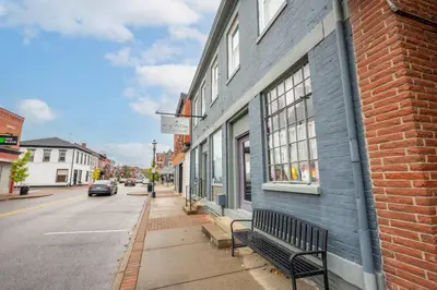 a bench sitting outside of a building on a street at The Washington Cottage - 6ppl in Harrison