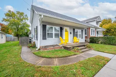 a house with two yellow chairs on the front porch at The Washington Cottage - 6ppl in Harrison