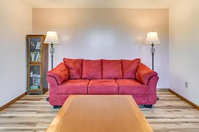 a red couch in a living room with a table at Dirt Road Digs - Quiet Home in Lakeville!