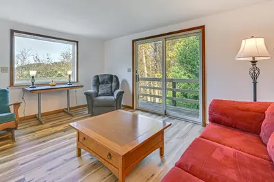 a living room with a red couch and a coffee table at Dirt Road Digs - Quiet Home in Lakeville!