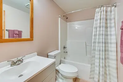 a bathroom with a sink and a toilet and a mirror at Dirt Road Digs - Quiet Home in Lakeville!