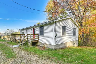 a small white house sitting on top of a field at Dirt Road Digs - Quiet Home in Lakeville!
