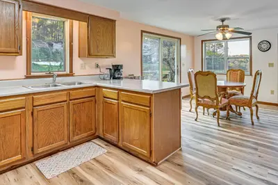 a kitchen with wooden cabinets and a table and chairs at Dirt Road Digs - Quiet Home in Lakeville!