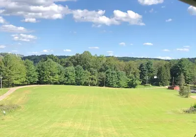 a large green field with trees in the background at The Lodge at Hocking Hills - 2 Hot Tubs - 6 acres - Lake access in Rockbridge