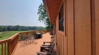 a deck with tables and chairs on the side of a building at The Lodge at Hocking Hills - 2 Hot Tubs - 6 acres - Lake access in Rockbridge