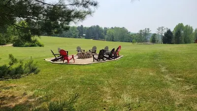 a group of chairs sitting in a field at The Lodge at Hocking Hills - 2 Hot Tubs - 6 acres - Lake access in Rockbridge