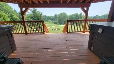 a large wooden deck with a view of a park at The Lodge at Hocking Hills - 2 Hot Tubs - 6 acres - Lake access in Rockbridge