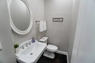 a bathroom with a sink and a toilet and a mirror at Spacious 4BR Home Near UD Oregon and DT Dayton in Dayton
