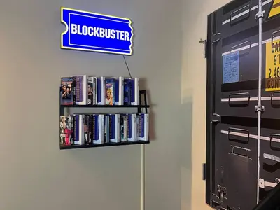 a shelf with dvds and a sign on a wall at Radical 80's Getaway! A Blast From The Past! in Sandusky