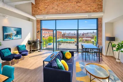a living room with a couch and a table at Downtown Sleeps 8 By Cedar Point & Sports Force! in Sandusky