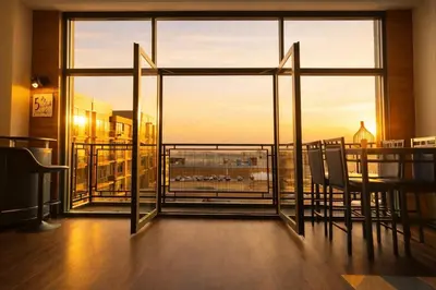 a room with a balcony with a view of the city at Downtown Sleeps 8 By Cedar Point & Sports Force! in Sandusky