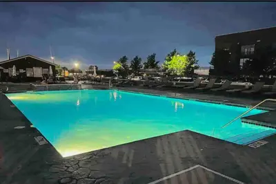 a large swimming pool at night at Downtown Sleeps 8 By Cedar Point & Sports Force! in Sandusky