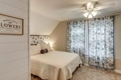a bedroom with a bed and a ceiling fan at 2 Mi to Dtwn Charming Sandusky Getaway with Hot Tub in Sandusky