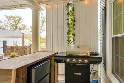 a screened in porch with a grill and a stove at 2 Mi to Dtwn Charming Sandusky Getaway with Hot Tub in Sandusky