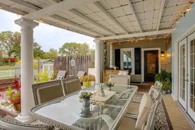 a patio with a glass table and chairs at 2 Mi to Dtwn Charming Sandusky Getaway with Hot Tub in Sandusky