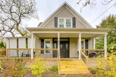 a small house with a porch with a wooden deck at 2 Mi to Dtwn Charming Sandusky Getaway with Hot Tub in Sandusky