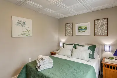a bedroom with a bed with a green bedspread at 2 Mi to Dtwn Charming Sandusky Getaway with Hot Tub in Sandusky