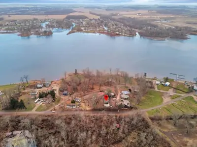 an aerial view of a house on a hill next to a lake at Canary Cottage in Thornville