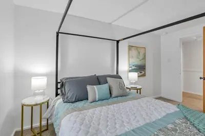 a bedroom with a large bed and two tables at Canary Cottage in Thornville