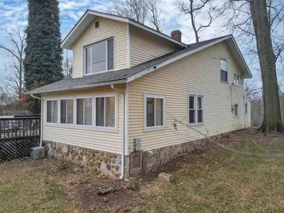 a white house with a roof on top of it at Canary Cottage in Thornville