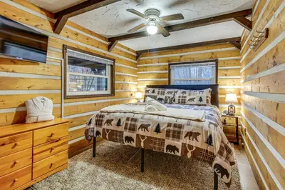 a bedroom with a bed in a log cabin at Lake Access and Hot Tub! Serene Rockbridge Cabin in Rockbridge