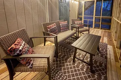 a porch with three chairs and a table on a porch at Lake Access and Hot Tub! Serene Rockbridge Cabin in Rockbridge
