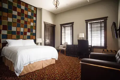 a bedroom with a bed and a chair and a couch at The Hackett Hotel in Marietta