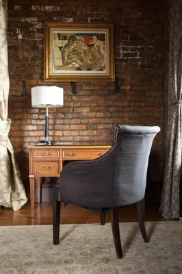 a chair sitting in front of a desk with a lamp at The Hackett Hotel in Marietta