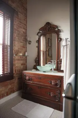 a bathroom with a sink and a mirror on a dresser at The Hackett Hotel in Marietta
