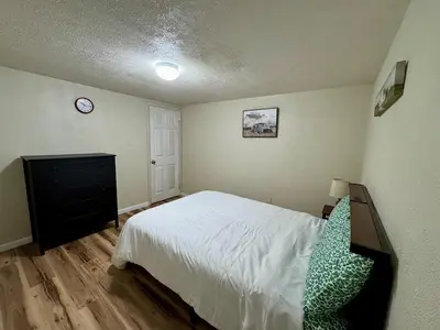 a bedroom with a bed and a dresser and a clock at Cozy house for small or big group in Bridgeport WV in Bridgeport