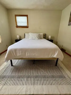 a large bed in a bedroom with two night stands at Cozy house for small or big group in Bridgeport WV in Bridgeport