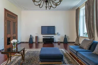 a living room with a blue couch and a tv at Cincinnati Hotel in Cincinnati