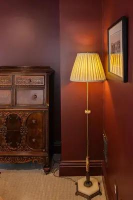 a lamp in the corner of a room next to a dresser at The Railway Retreat - Downtown Sylvania in Sylvania