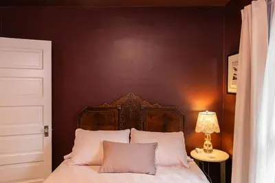a bedroom with a bed with a brown wall at The Railway Retreat - Downtown Sylvania in Sylvania