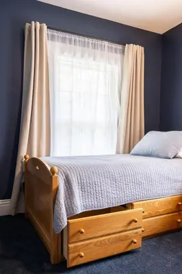 a bedroom with a wooden bed with a window at The Railway Retreat - Downtown Sylvania in Sylvania