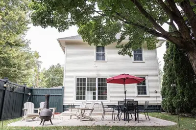 a patio with a table and chairs and an umbrella at The Railway Retreat - Downtown Sylvania in Sylvania