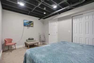 a bedroom with a bed and a door and a chair at Colonial on Crane in Buckeye Lake