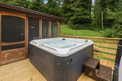 a hot tub on the deck of a house at Lakefront in Logan (In the heart of Hocking Hills) in Logan