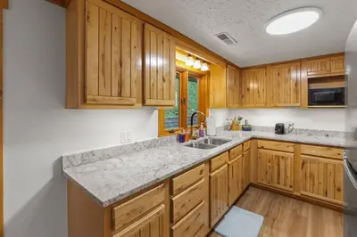 a kitchen with wooden cabinets and a granite counter top at Lakefront in Logan (In the heart of Hocking Hills) in Logan