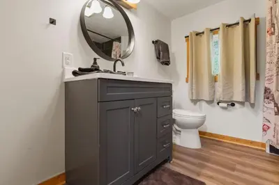 a bathroom with a sink and a mirror and a toilet at Lakefront in Logan (In the heart of Hocking Hills) in Logan