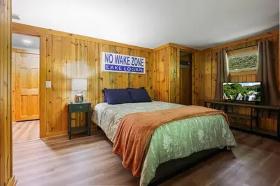 a bedroom with a bed with a sign on the wall at Lakefront in Logan (In the heart of Hocking Hills) in Logan