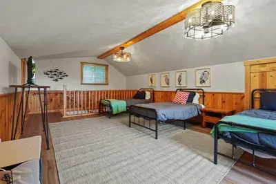 a living room with two beds and a rug at Lakefront in Logan (In the heart of Hocking Hills) in Logan