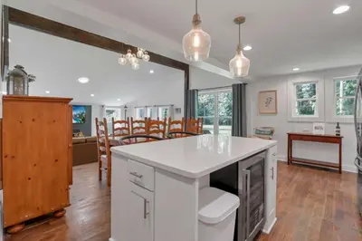 a kitchen with a white island and a dining room at Adventures at Aspen Way in Rockbridge